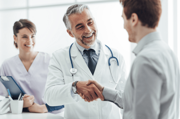 Medico stretta di mano con paziente comunicazione positiva