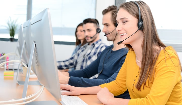 portrait-of-a-beautiful-and-cheerful-young-woman-telephone-operator-with-headset-working-on-desktop-computer-in-row-in-a-customer-service-call-support-2