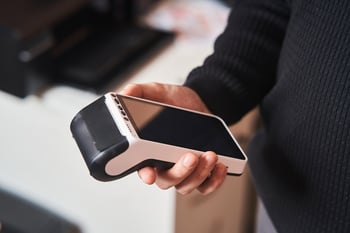 Bank-terminal-for-contactless-payment.-Young-man-holds-a-terminal-in-his-hands-1211312907_1258x838