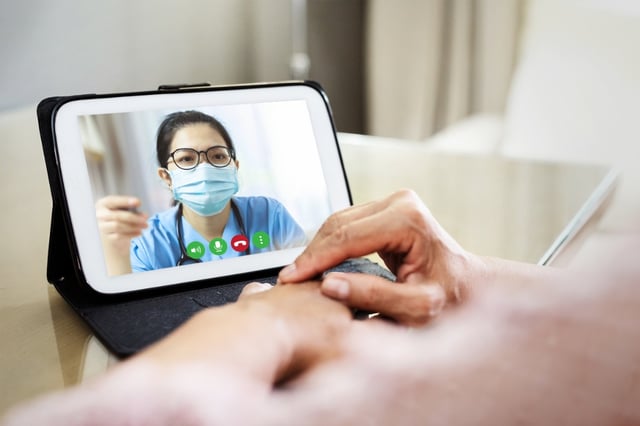 Dottore che usa la medicina digitale e la telemedicina per comunicare con paziente disabile